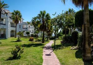 a path through a park with palm trees and a building at Appartment Penthouse 7- 6 in La Cala de Mijas