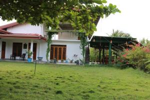 una casa con un prato davanti di Wadula Resort a Nochchiyagama