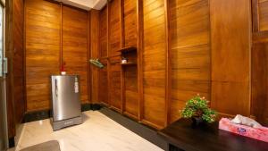 ein Raum mit Holzwänden und einem Kühlschrank in der Unterkunft Shady mango villa in Sigiriya