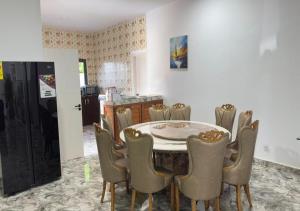 アシニにあるAKl RESIDENCEのテーブルと椅子と冷蔵庫のあるキッチン