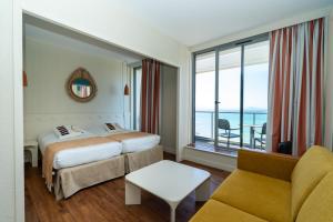 a hotel room with two beds and a couch at Résidence Vacances Bleues Le Grand Large in Biarritz +73 photos