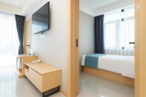 ein Hotelzimmer mit einem Bett und einem Fernseher in der Unterkunft ARK HOTEL in Phnom Penh