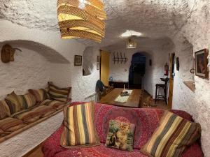 un soggiorno con un divano e un tavolo di Cuevas el Torriblanco a Gorafe Altre 90 foto