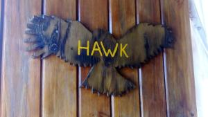 Un cartel con forma de pájaro en una pared de madera con la palabra halcón. en Eagles Nest hostel plus self catering private units, en Coffee Bay