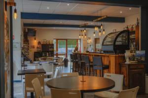 ein Restaurant mit Tischen und Stühlen und eine Bar in der Unterkunft Camping du Valentin in Laruns