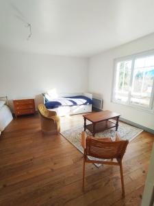 a living room with a bed and a table at Gite La Tanière in Siradan