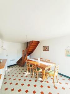 a dining room with a table and chairs and a staircase at Gite La Tanière in Siradan