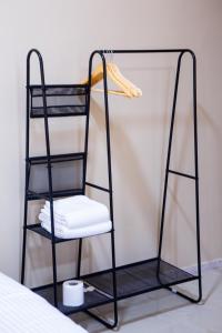 ein schwarzes Leiterregal mit einem weißen Stuhl in der Unterkunft The Garden Inn نزل الحدیقة in Nizwa