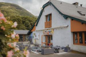 ein Gebäude mit Tischen und Stühlen davor in der Unterkunft Camping du Valentin in Laruns