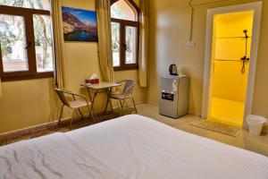 ein Schlafzimmer mit einem Bett und einem Tisch und Stühlen in der Unterkunft The Garden Inn نزل الحدیقة in Nizwa