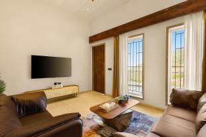 uma sala de estar com um sofá e uma TV de tela plana em ELIVAAS Le Aravella 3 BHK Villa with Gazebo, Balcony & Private Pool em Lakāwās