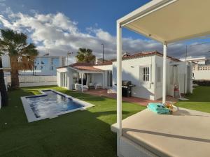 a backyard with a swimming pool and a house at Villa near the ocean with private pool and garage in San Miguel de Abona