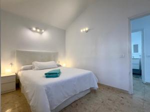 a bedroom with a white bed with a green towel on it at Villa near the ocean with private pool and garage in San Miguel de Abona +58 photos