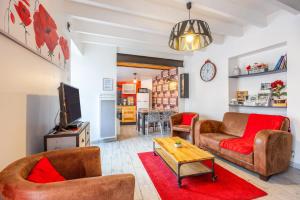 ein Wohnzimmer mit zwei Sofas und einem Fernseher in der Unterkunft Le Clemenceau in Les Épesses