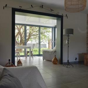 a living room with a large sliding glass door with a table at BOCENNO Catherine in Ambon