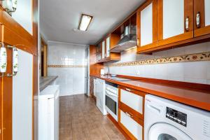 una cucina con elettrodomestici bianchi e armadietti in legno di Villa Marquesa - Punta Umbria a Punta Umbría