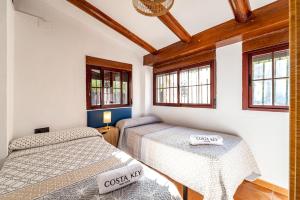 due letti in una stanza con due finestre di Villa Marquesa - Punta Umbria a Punta Umbría Altre 26 foto