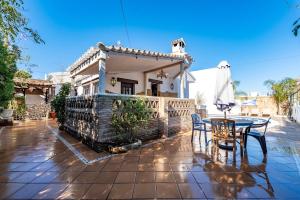 una casa con patio arredato con tavolo e sedie di Villa Marquesa - Punta Umbria a Punta Umbría