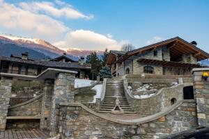 un edificio de piedra con escaleras frente a una montaña en Chalet Morge, en La Salle