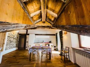 comedor con techos de madera, mesa y sillas en Chalet Morge, en La Salle