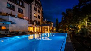 basen przed budynkiem w nocy w obiekcie Hotel Spa Restaurant Domaine du Moulin w mieście Ensisheim