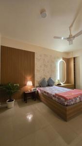 a bedroom with a large bed and a table at Spacious Lakeview Apartment with Balcony in Lucknow