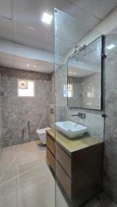 a bathroom with a sink and a toilet and a mirror at Spacious Lakeview Apartment with Balcony in Lucknow +8 photos