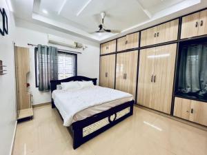 ein Schlafzimmer mit einem Bett und Holzschränken in der Unterkunft MHR Vacation Home & Mini Function Hall in Khammam