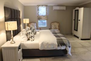 1 dormitorio con 1 cama, 2 lámparas y ventana en Nuwerus Lodge Paarl, en Paarl