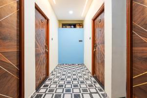 einen Flur mit einer weißen Tür und einem schwarz-weißen Fliesenboden in der Unterkunft HOTEL O KPS INN in Itwāri