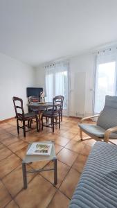 a living room with a table and chairs at L'Acacia, F2 terrasse et jardin,plage à 400mètres in Houlgate