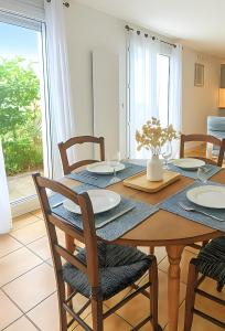 a dining room with a table with chairs and a window at L'Acacia, F2 terrasse et jardin,plage à 400mètres in Houlgate