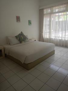 a bedroom with a large white bed with a window at Casavina house 201 in Canggu +39 photos