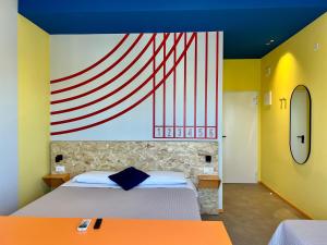 ein Schlafzimmer mit einem Bett und einem großen Gemälde an der Wand in der Unterkunft Fantini Club Hotel in Cervia