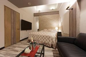 ein Hotelzimmer mit einem Bett und einer Couch in der Unterkunft ホテル Ano in Kanuma + 19 Fotos