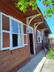 una casa rossa con finestre bianche e una porta di Hospedagem Maranata a Santo André