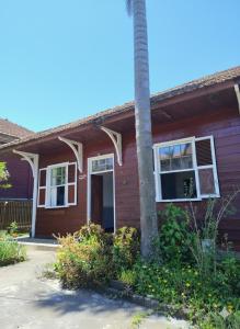 una casa rossa con una palma di fronte di Hospedagem Maranata a Santo André