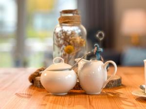 a table with two tea cups and a glass jar at Sonnenbirke in Fuhlendorf