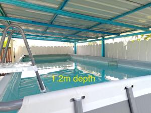 an empty swimming pool with a blue ceiling at Echah's Homestay-mslim only in Jeram
