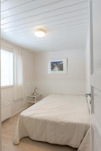 una camera da letto bianca con un letto e una finestra di Meriheinä a Kalajoki