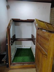 ein leerer Raum mit grünem Boden und einer Holztür in der Unterkunft Bhatye Beach Resort Rejunuvation in Ratnagiri