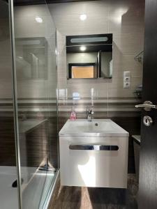 a bathroom with a white sink and a shower at Art Apartments in Hajdúszoboszló +106 photos