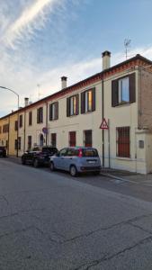 a building with two cars parked in front of it at Loftino42 - Monolocale Open Space a Ferrara, Biciclette incluse in Ferrara