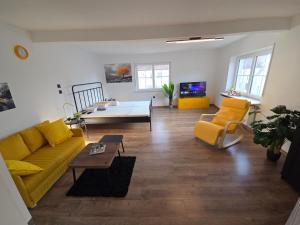 a living room with a yellow couch and a table at Zum grünen Häusle in Kolitzheim