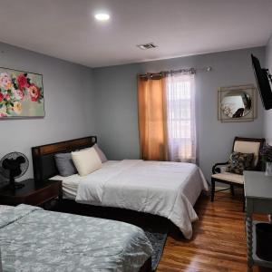 Lovely 3BR Home Quick Trip to NYC Prudential في نيوآرك: غرفة نوم بها سريرين وكرسي