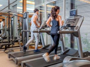 a man and a woman on a treadmill in a gym at Pullman Bangkok King Power in Bangkok