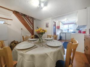 a dining room table with plates and flowers on it at Jasmine Cottage - Uk50585 in Bintree