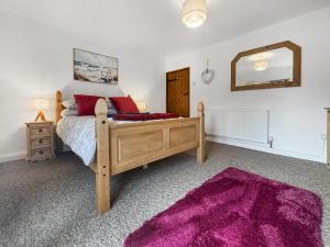 a bedroom with a wooden bed and a mirror at Jasmine Cottage - Uk50585 in Bintree