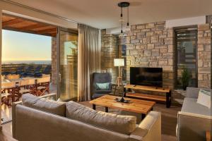 ein Wohnzimmer mit Sofa und Fernseher in der Unterkunft Alba Lilia II in Pitsidia