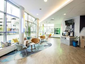 una grande stanza con sedie, tavoli e finestre di ibis budget Warszawa Centrum a Varsavia